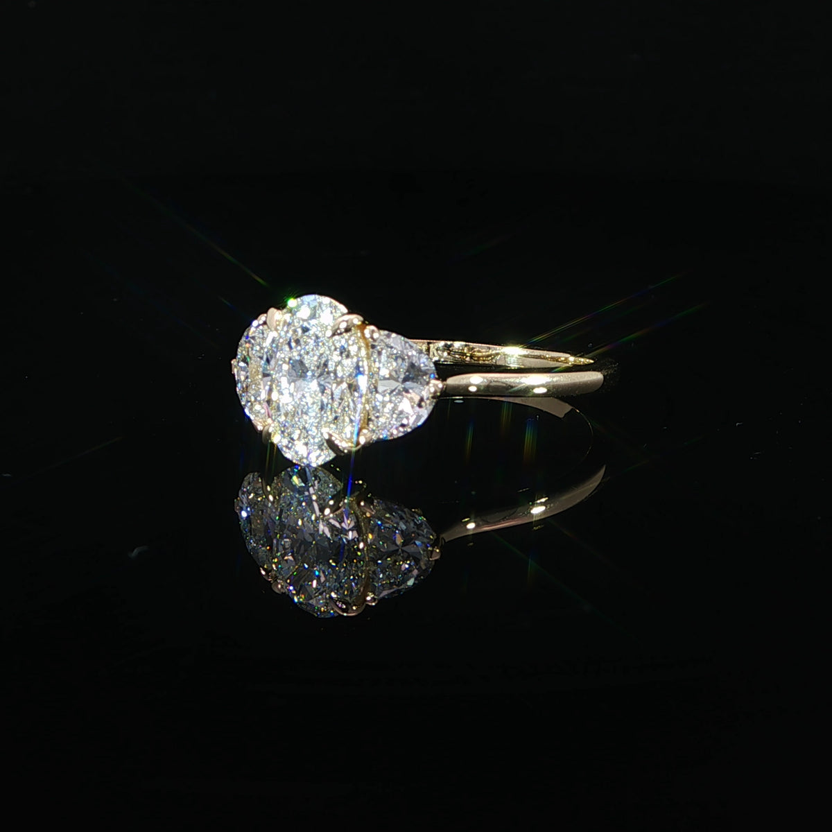 1.52-carat oval lab-grown diamond engagement ring with two half-moon side diamonds in 14K yellow gold.