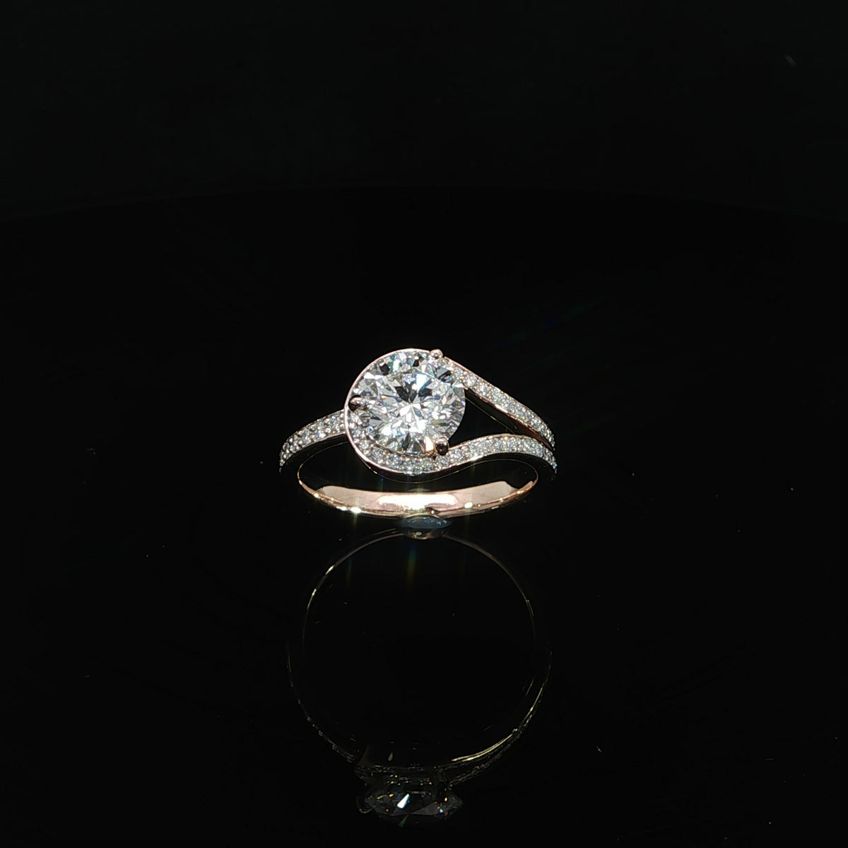 Angled view of a 1.54 carat round diamond bypass ring with sweeping pavé diamond accents.