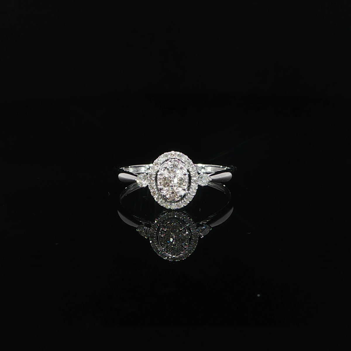 Front view of a 10K white gold 0.24 CTW natural diamond ring with an oval-shaped cluster and diamond halo.