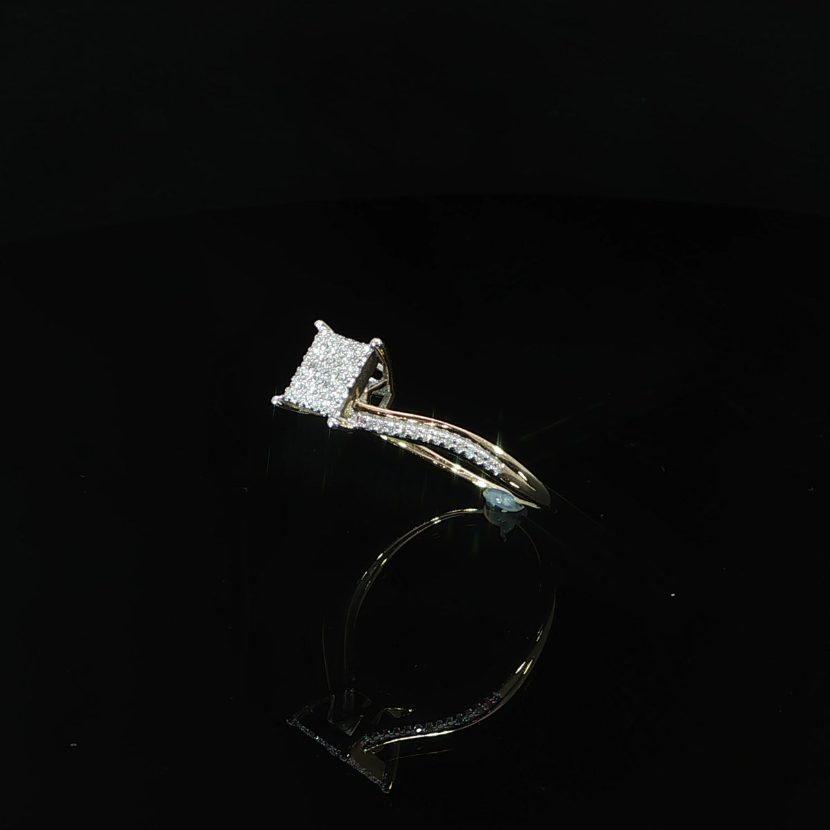 Standing side angle of a 10K yellow gold diamond cluster ring with a raised setting and open gallery.