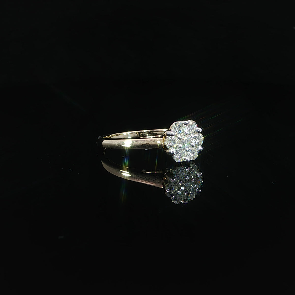 Three-quarter view of a 10K yellow gold 0.50 CTW seven-diamond cluster ring with its band extending to the left.