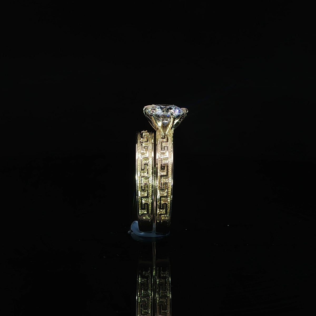 Side view of a 10K yellow gold bridal set with a raised 1.21 CT round diamond and matching engraved wedding band.