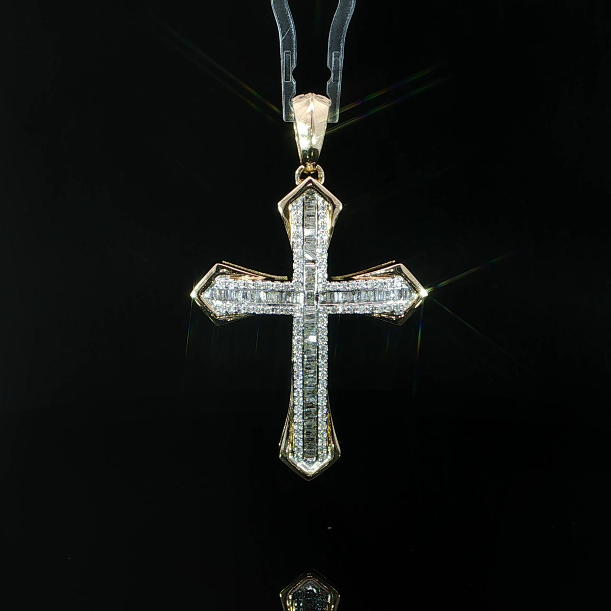 Front view of a 10K yellow gold cross pendant with baguette diamonds and a round diamond halo.