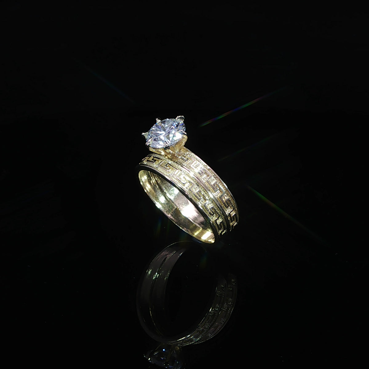 10K yellow gold engagement ring and matching band, showing Greek key engraving beneath a 1.21 CT round diamond.