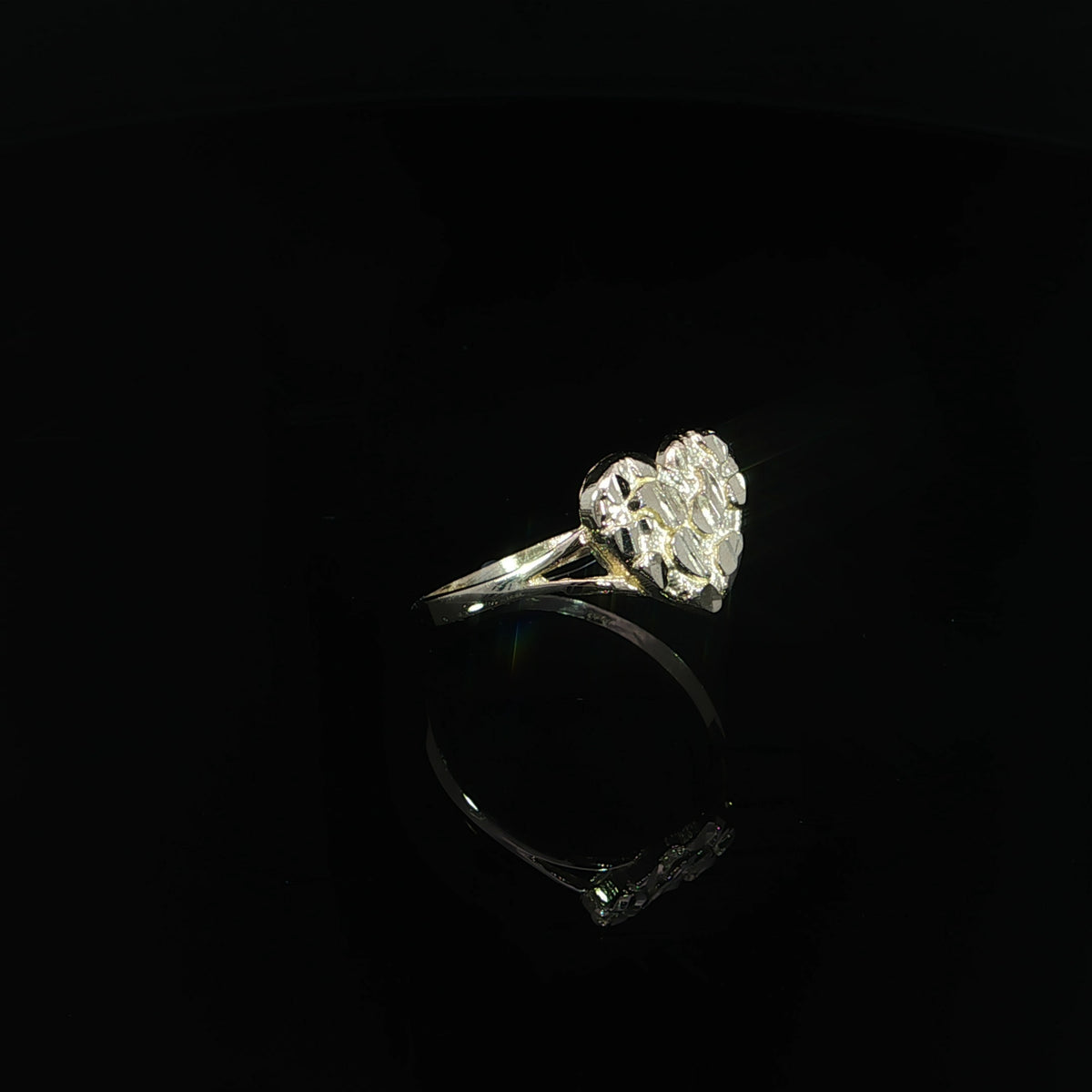 Three-quarter view of a 10K yellow gold heart nugget ring showing its textured face and band.