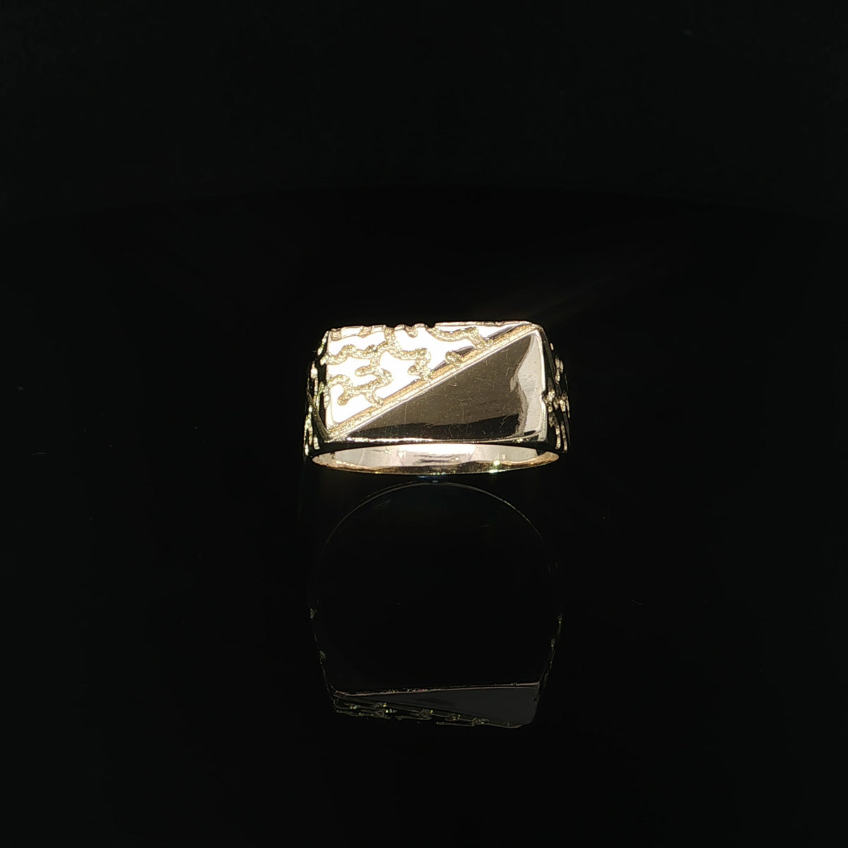 Front view of a 14K yellow gold men’s nugget ring with a rectangular face divided diagonally into textured and polished sections.