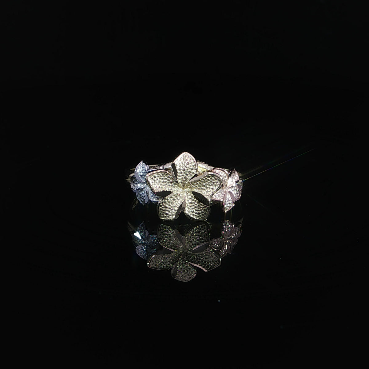Front view of a 14K gold plumeria ring with a 10mm center flower