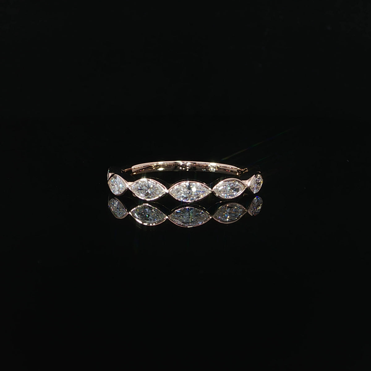 Front view of a 14K rose gold band with horizontally set marquise diamonds in polished bezel settings.