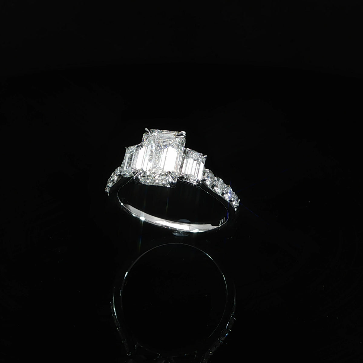 14K white gold three-stone engagement ring with a 2.06 carat emerald cut lab grown center diamond and matching side diamonds.