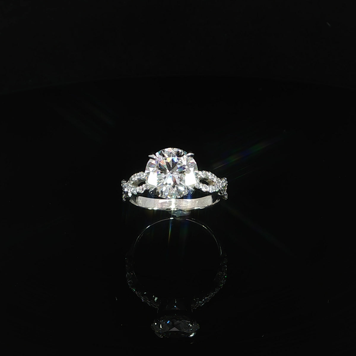 Resting front view of a 14K white gold 3.37 CTW diamond ring with a round center and looping diamond shoulders.