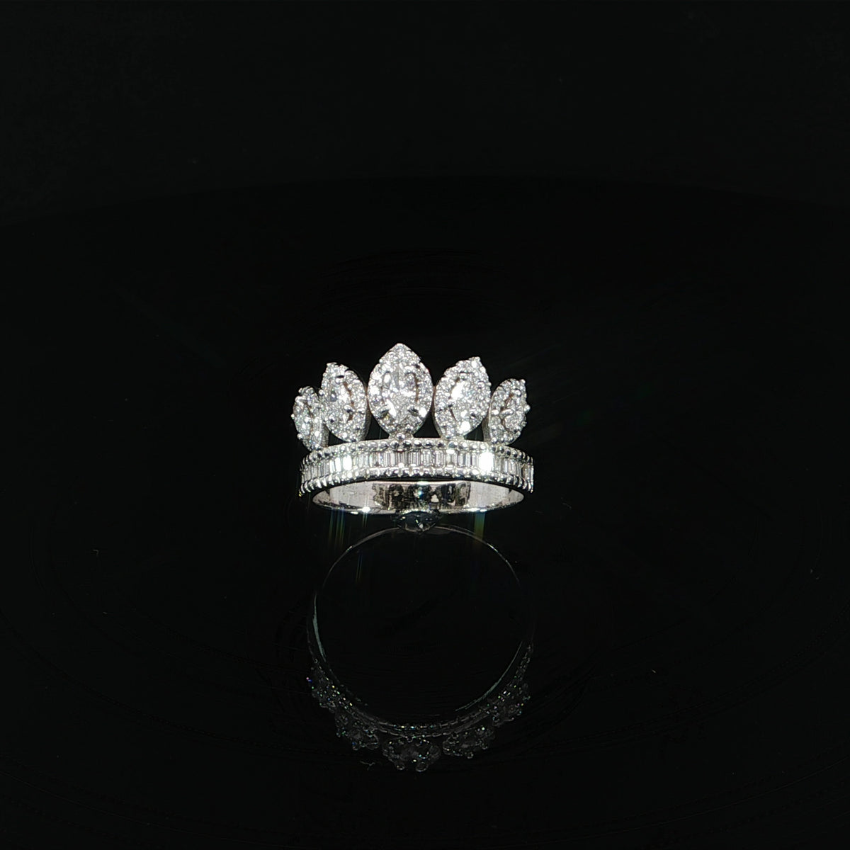 Elevated view of a white gold crown ring with marquise diamonds above a baguette diamond band.