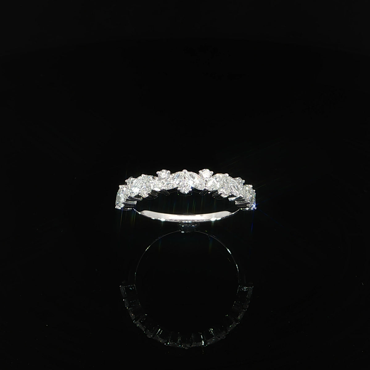 Angled view of a 14K white gold multi-shape diamond band with a staggered arrangement of stones.