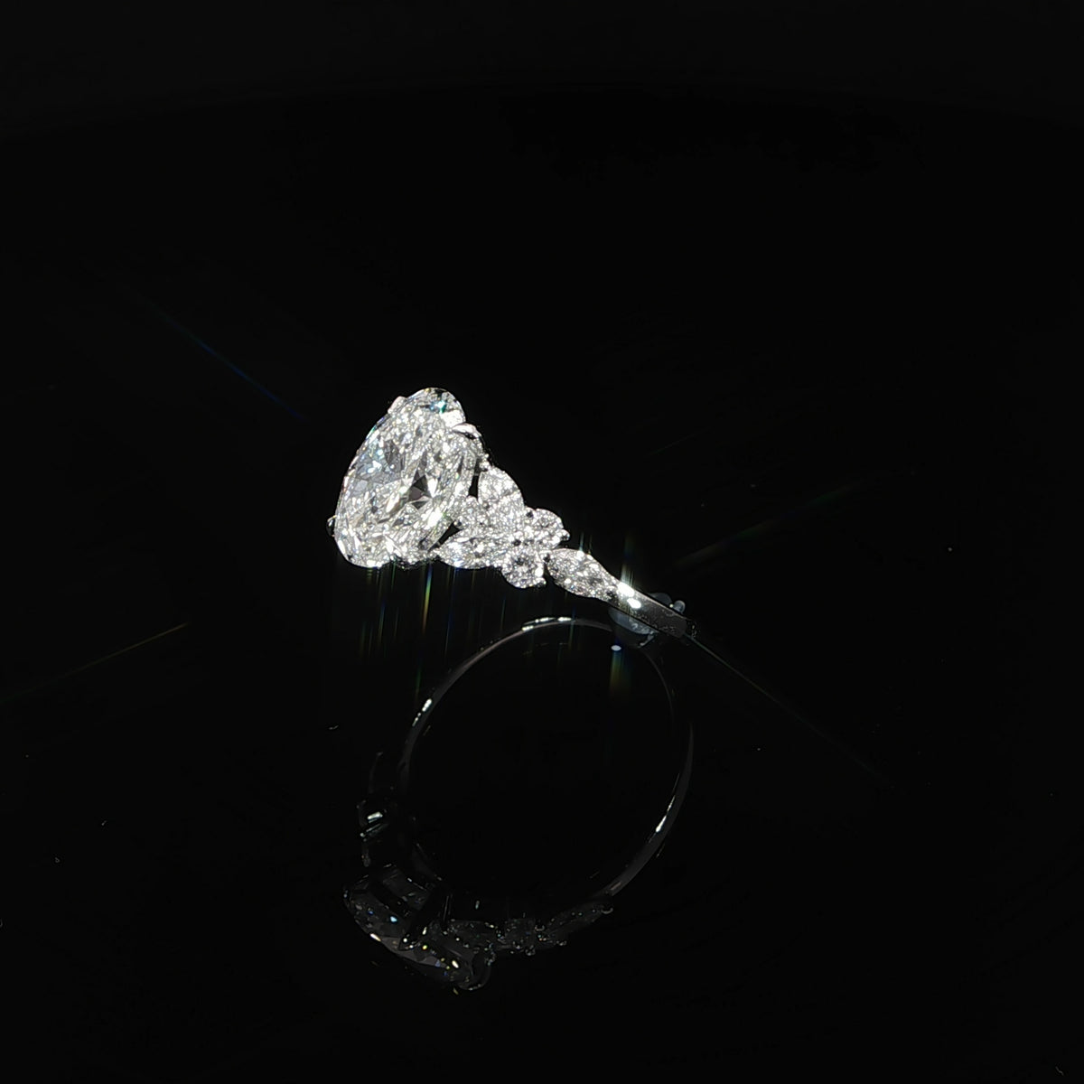 Angled view of a 2 carat oval lab grown diamond ring with marquise and round diamond accents in white gold.