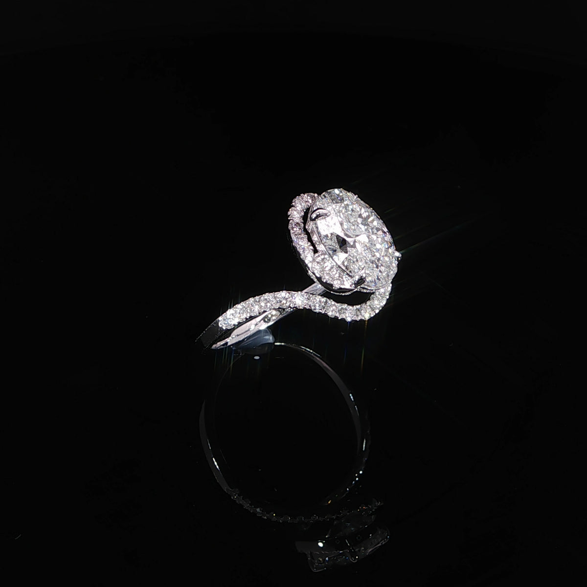 Angled view of a 14K white gold oval halo engagement ring with diamond-accented bypass shoulders.
