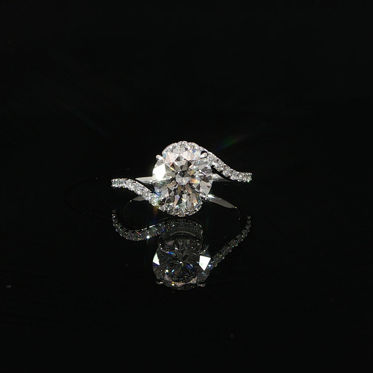Front view of a round diamond engagement ring with asymmetrical diamond-accented shoulders.