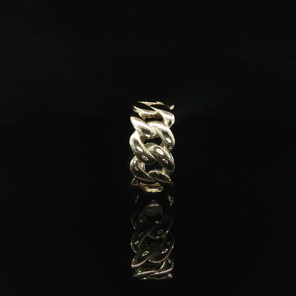 Detailed view of a 14K yellow gold Cuban link ring highlighting the open spaces between its sculpted chain links and the supporting gold band.