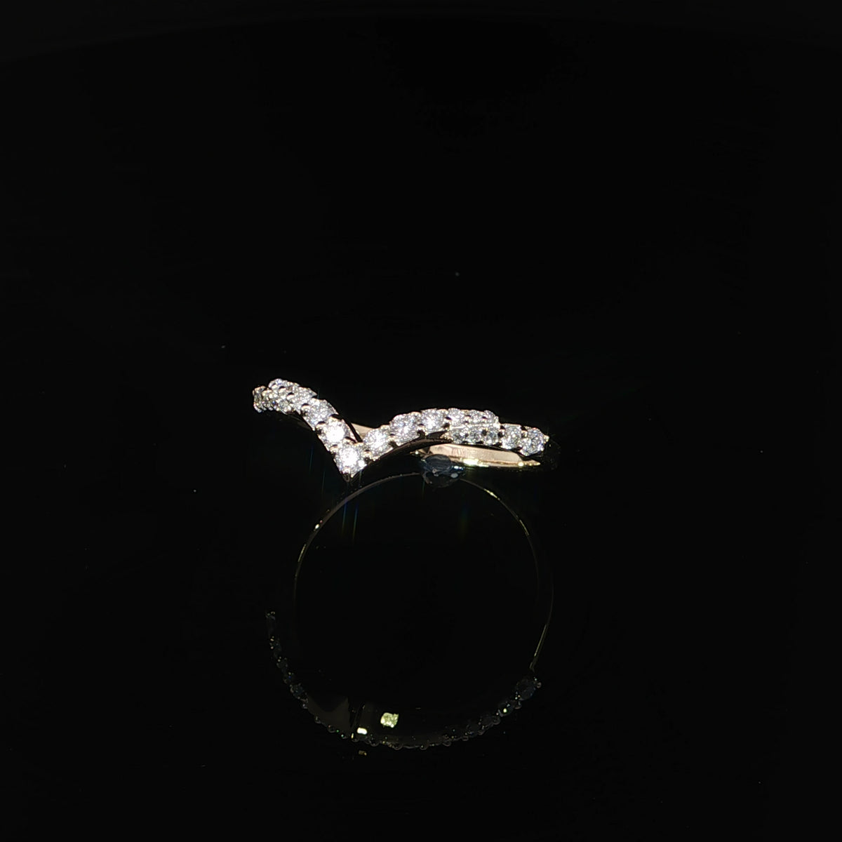 Three-quarter view of a diamond contour ring showing the transition from diamond settings to polished yellow gold.