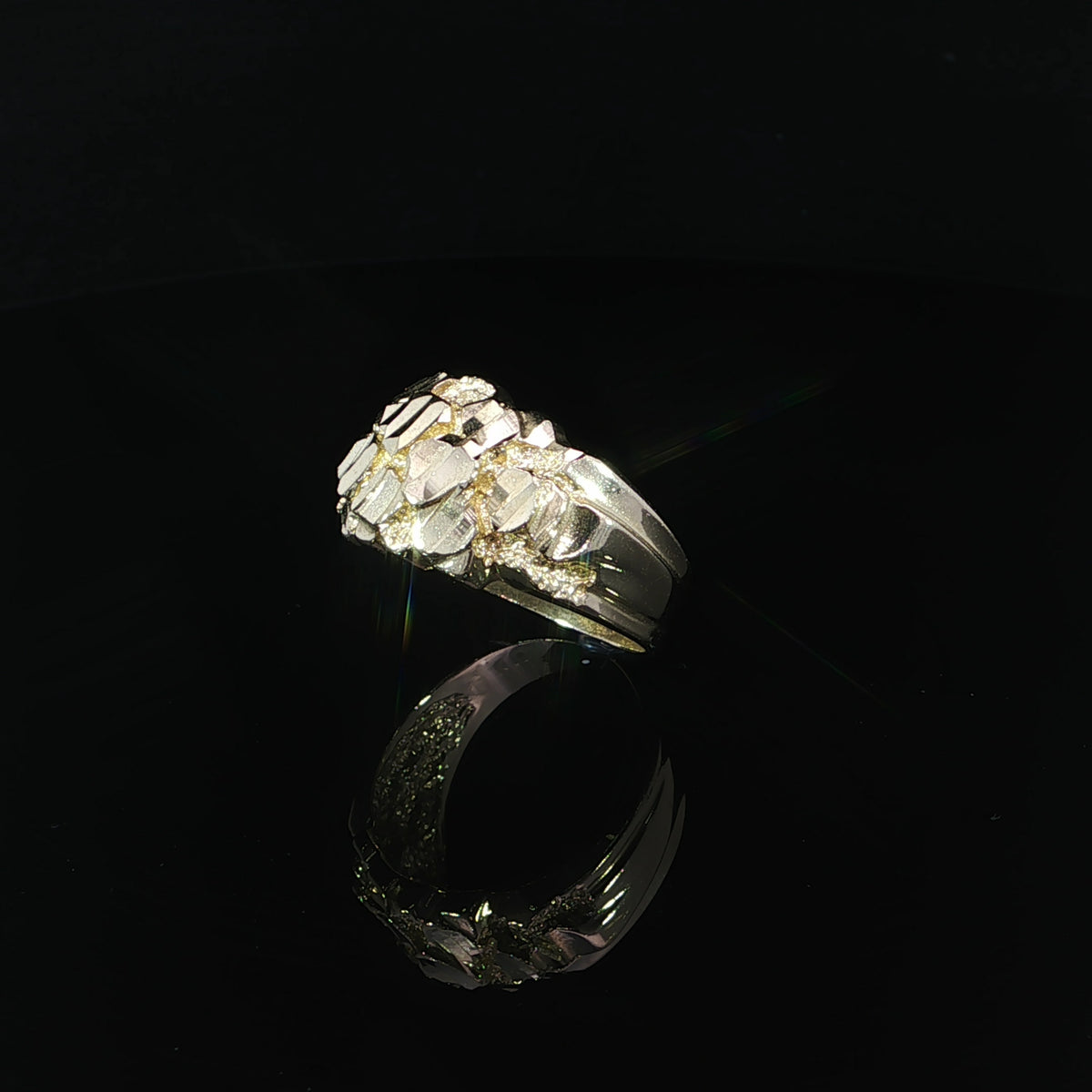 Left side angled view of a 14K yellow gold nugget ring highlighting its irregular faceted top, reflective gold surfaces, and tapered band.