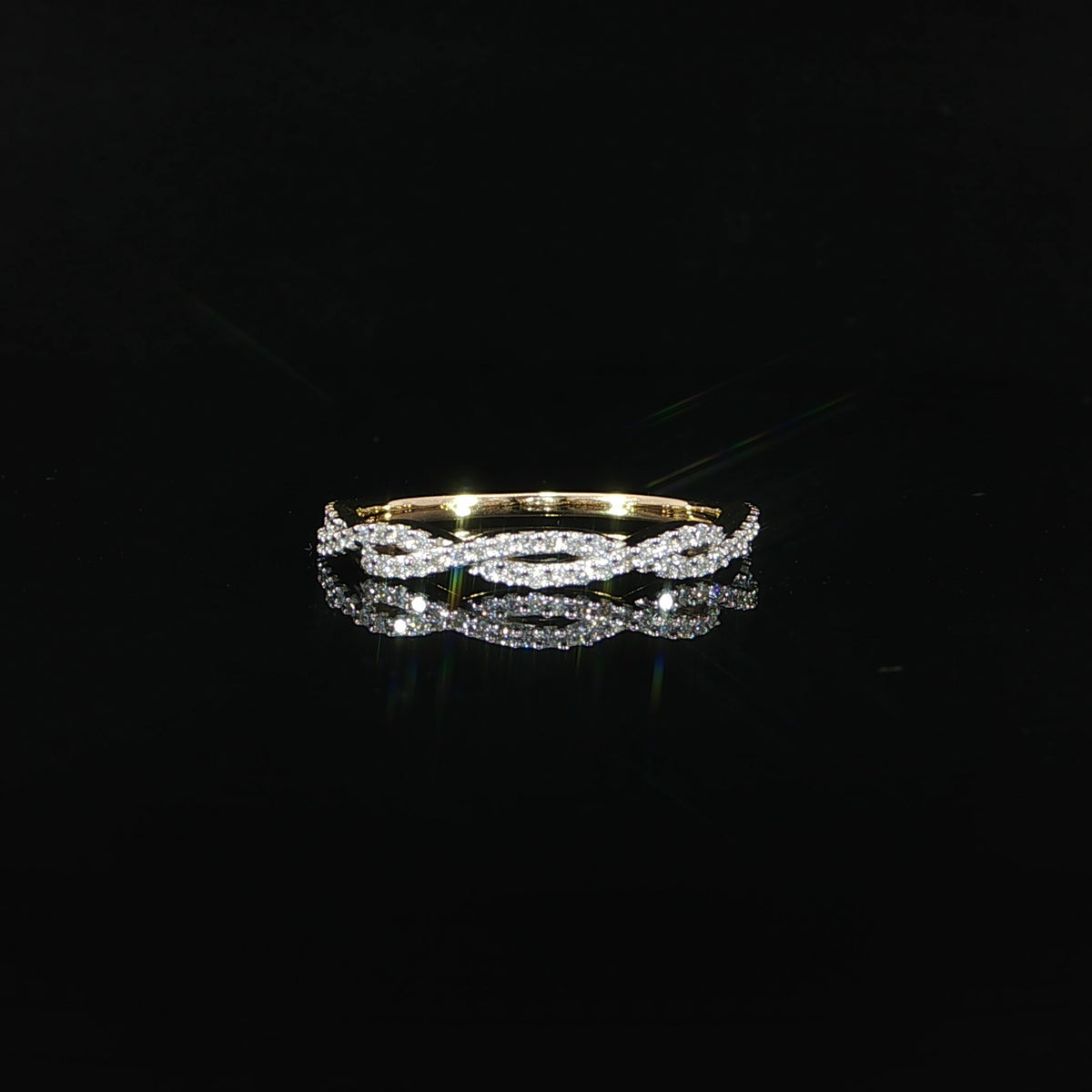 Small round diamonds trace intertwined strands across the front of a 14K yellow gold band.