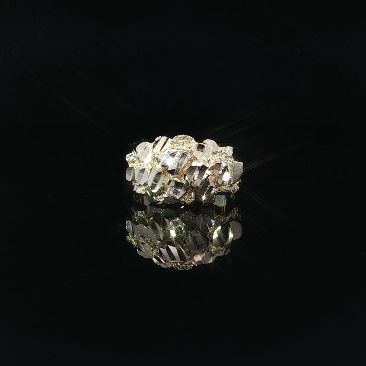 Detailed view of a men's 14K yellow gold nugget ring featuring highly reflective, angular diamond-cut surfaces and textured gold accents.