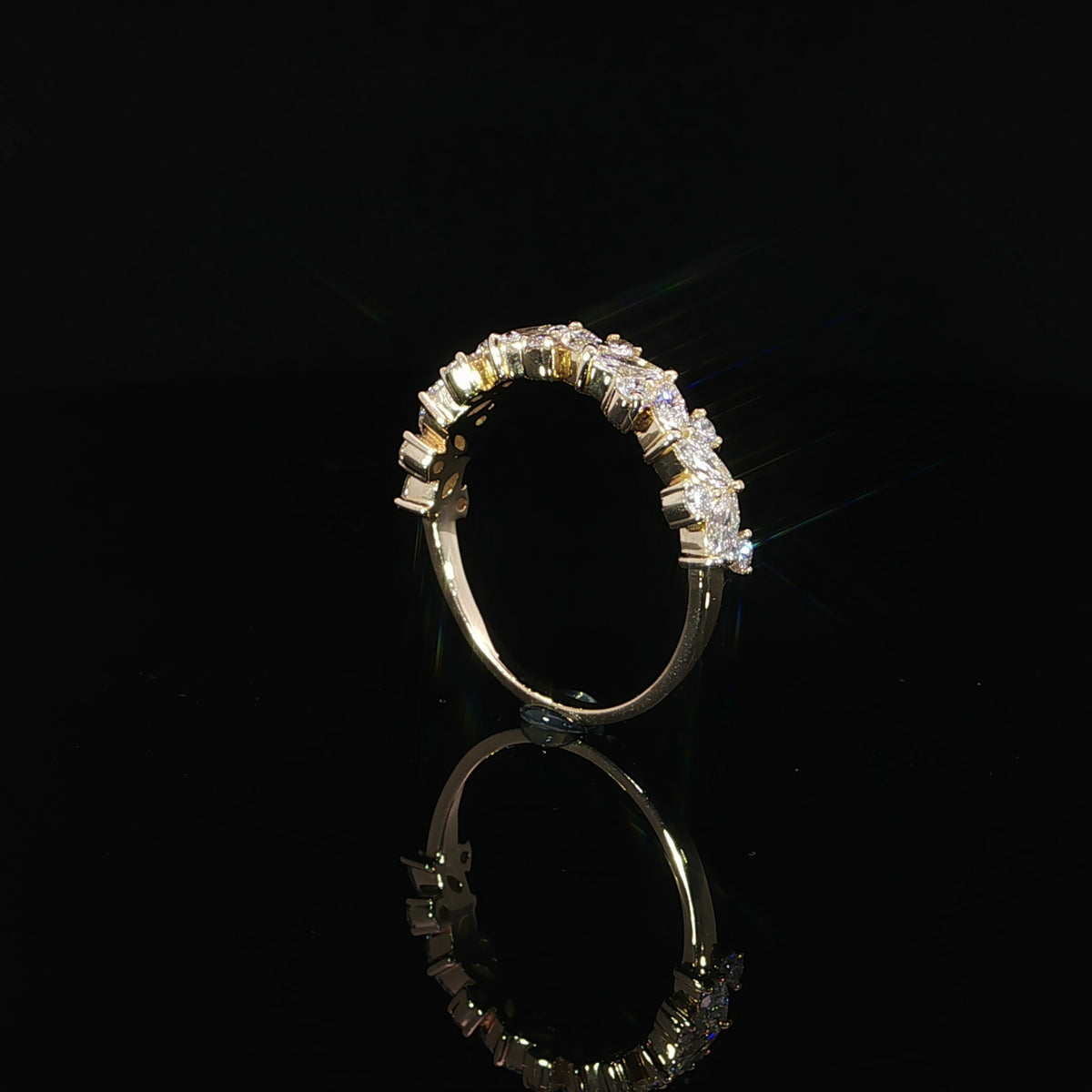 Upright side profile of a multi-shape diamond band showing raised gold settings and a polished lower shank.