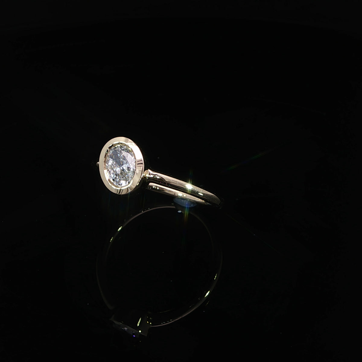 14K yellow gold engagement ring with a 0.70 carat oval lab grown diamond in a full bezel setting.