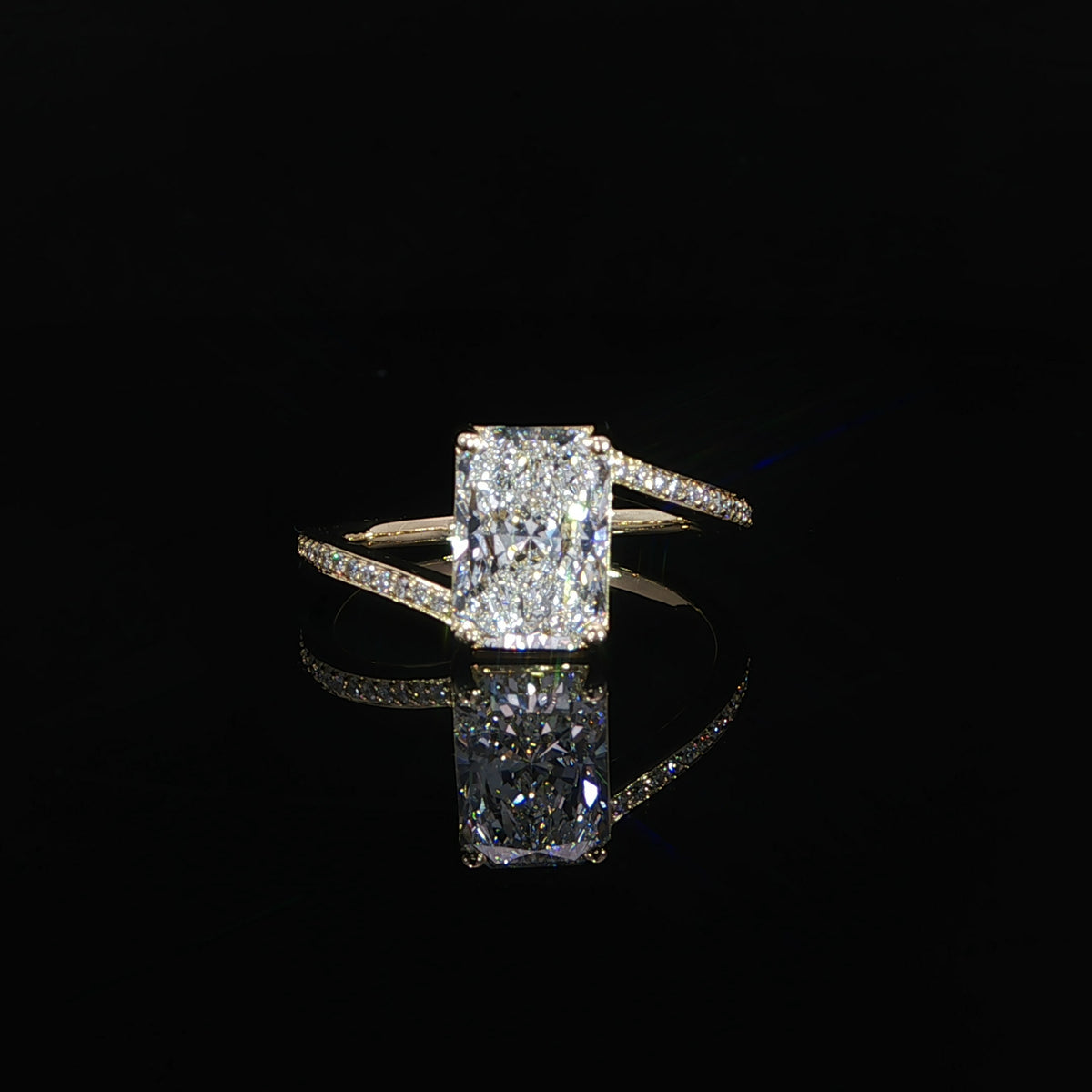 Front view of a radiant diamond ring with shoulders sweeping toward opposite ends of the center
