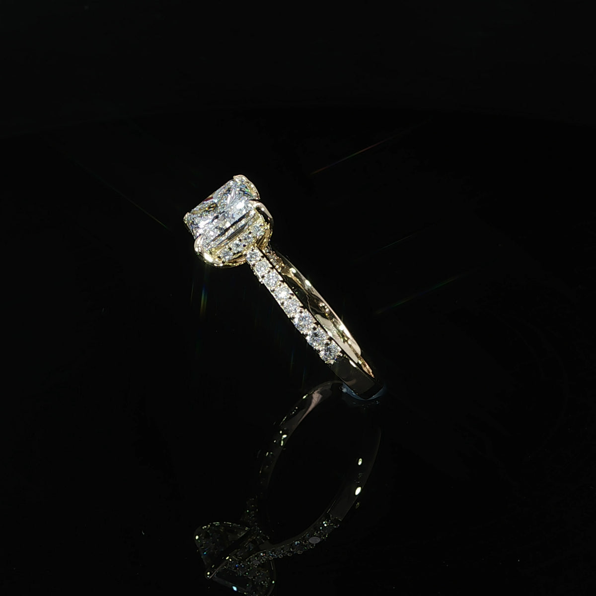 Angled view of a 2.02 carat princess cut diamond engagement ring with a pavé band in yellow gold.