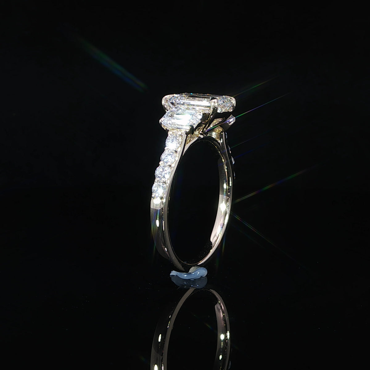 3.10 CTW lab grown diamond engagement ring with an emerald cut center stone in 14K yellow gold.