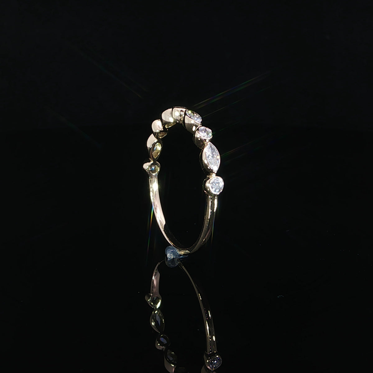 14K yellow gold ring featuring alternating marquise and round brilliant lab grown diamonds in delicate bezel settings against a black background.