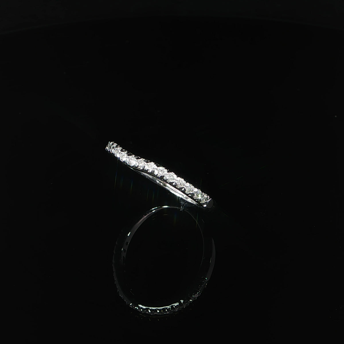 Three-quarter view of a delicate 14K white gold diamond contour ring featuring small lab grown diamonds and a slender polished band.