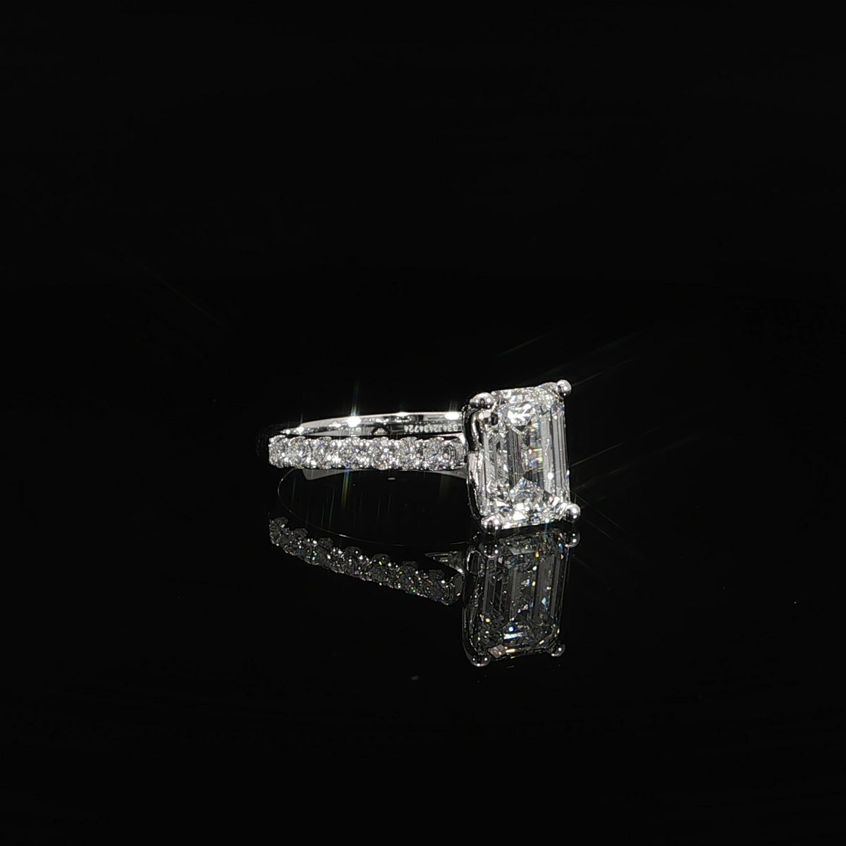 Front view of an emerald cut diamond solitaire engagement ring in 14K white gold.
