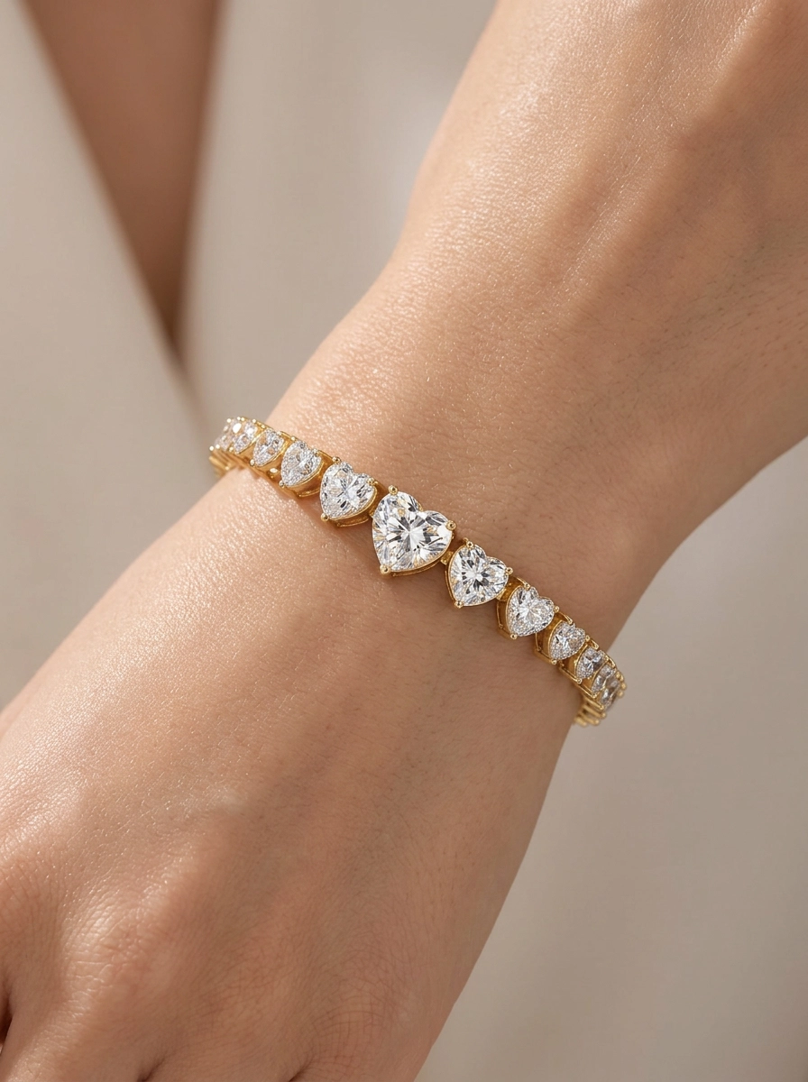 Female model wearing a sterling silver graduated heart moissanite tennis bracelet