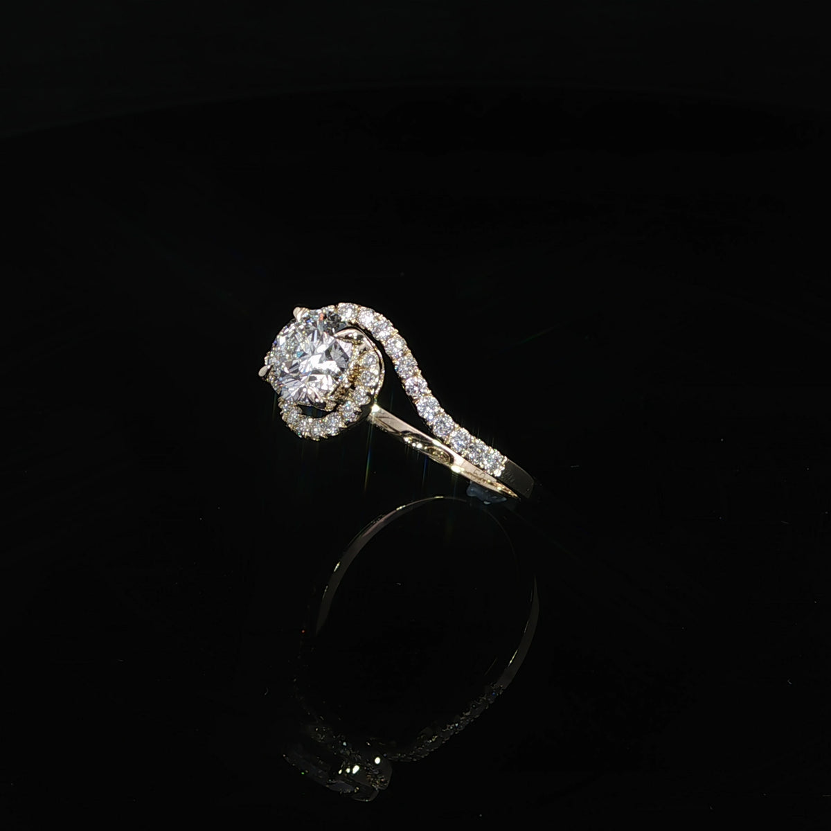 Angled view of 14K yellow gold flowing bypass engagement ring with round center diamond