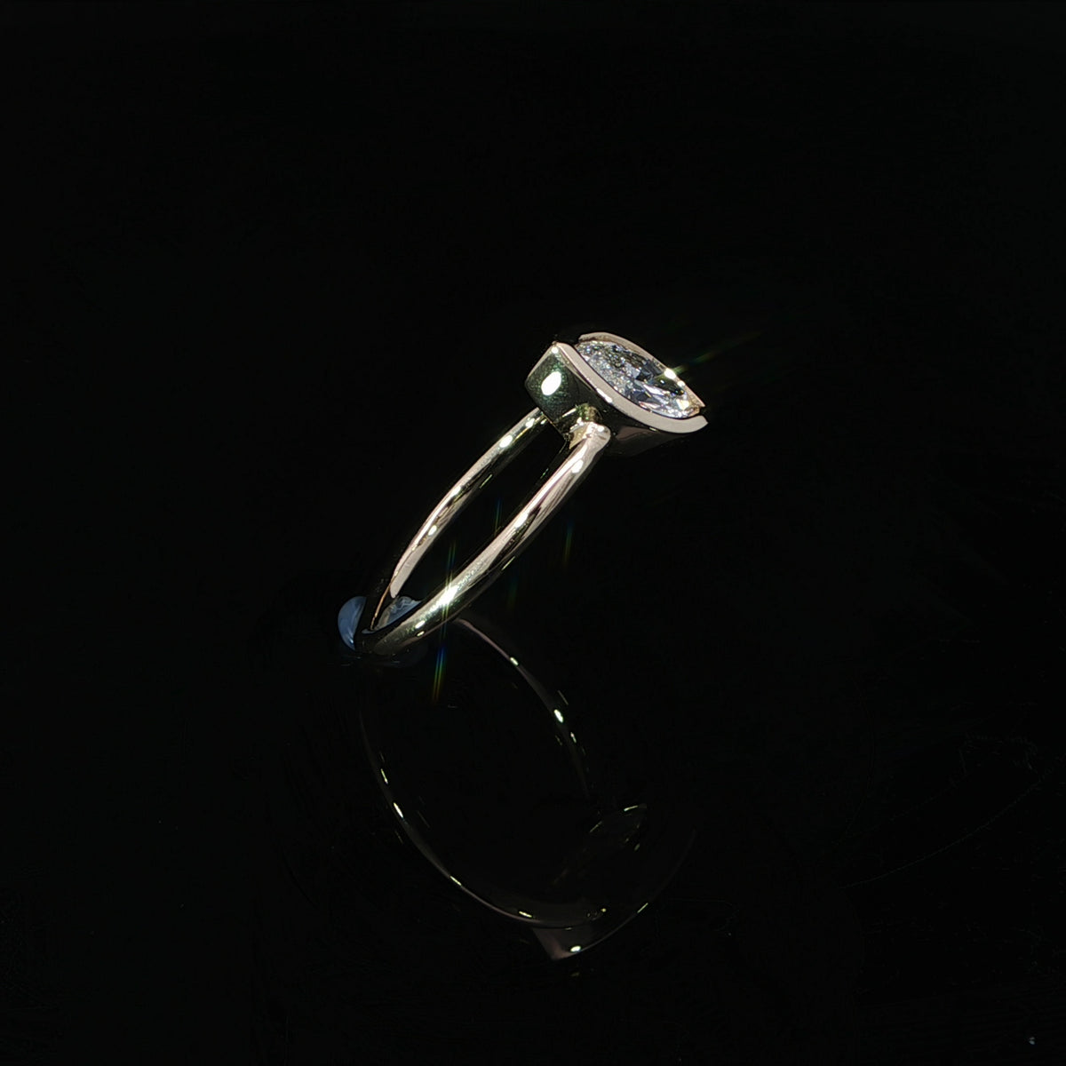 Yellow gold solitaire engagement ring with a marquise diamond secured in a smooth bezel setting.