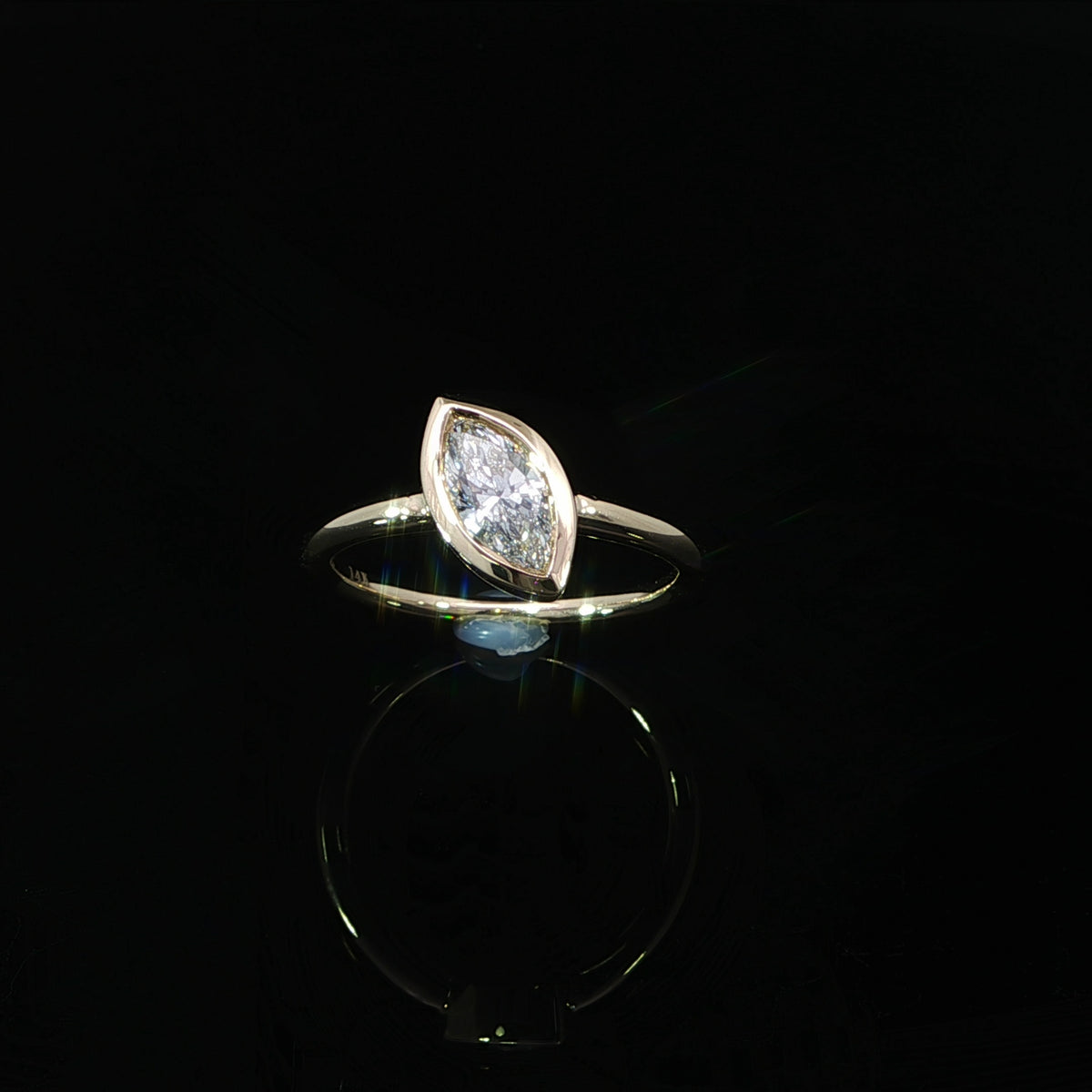 14K yellow gold engagement ring with a marquise lab grown diamond in a full bezel setting.