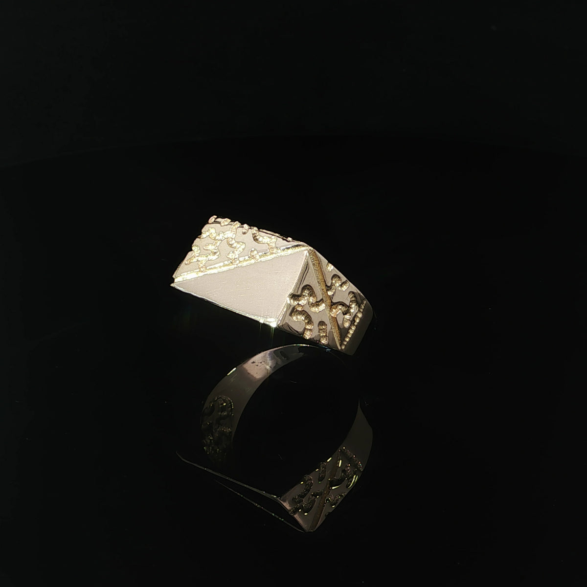 Three-quarter view of a men’s gold nugget ring with textured shoulder details framed by diagonal borders.