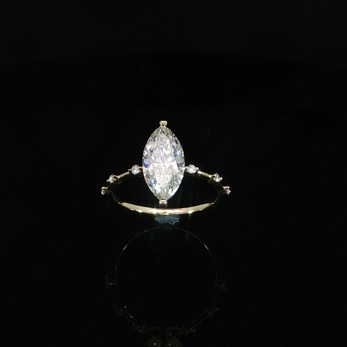 Modern marquise diamond engagement ring with a delicate station-style band in 14K yellow gold.