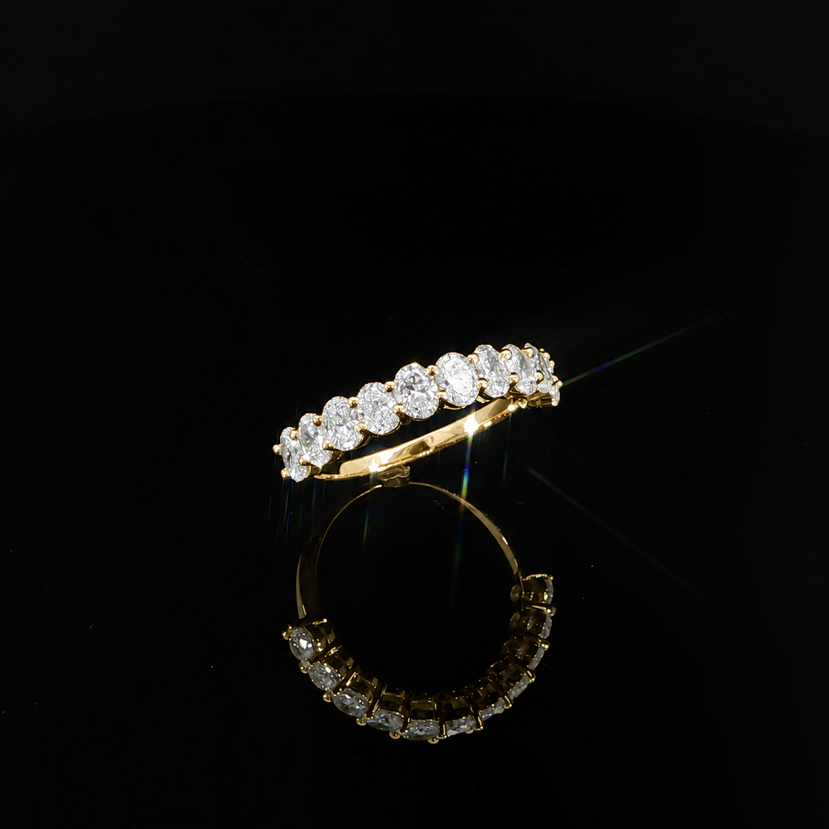 Three-quarter view of a 14K yellow gold wedding band featuring 1.48 CTW of oval lab-grown diamonds.