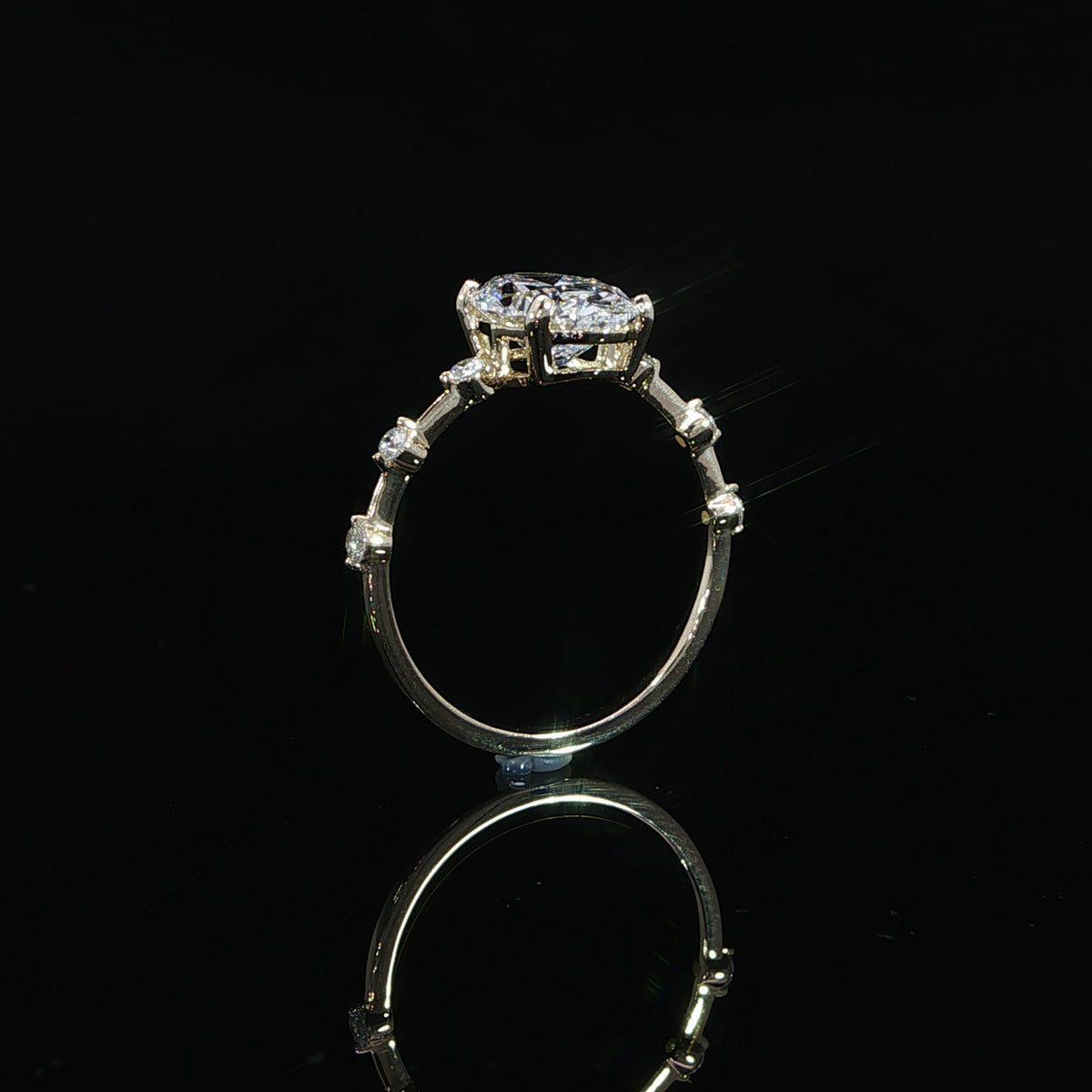 Detailed view of the raised setting supporting the oval center diamond above the yellow gold band.