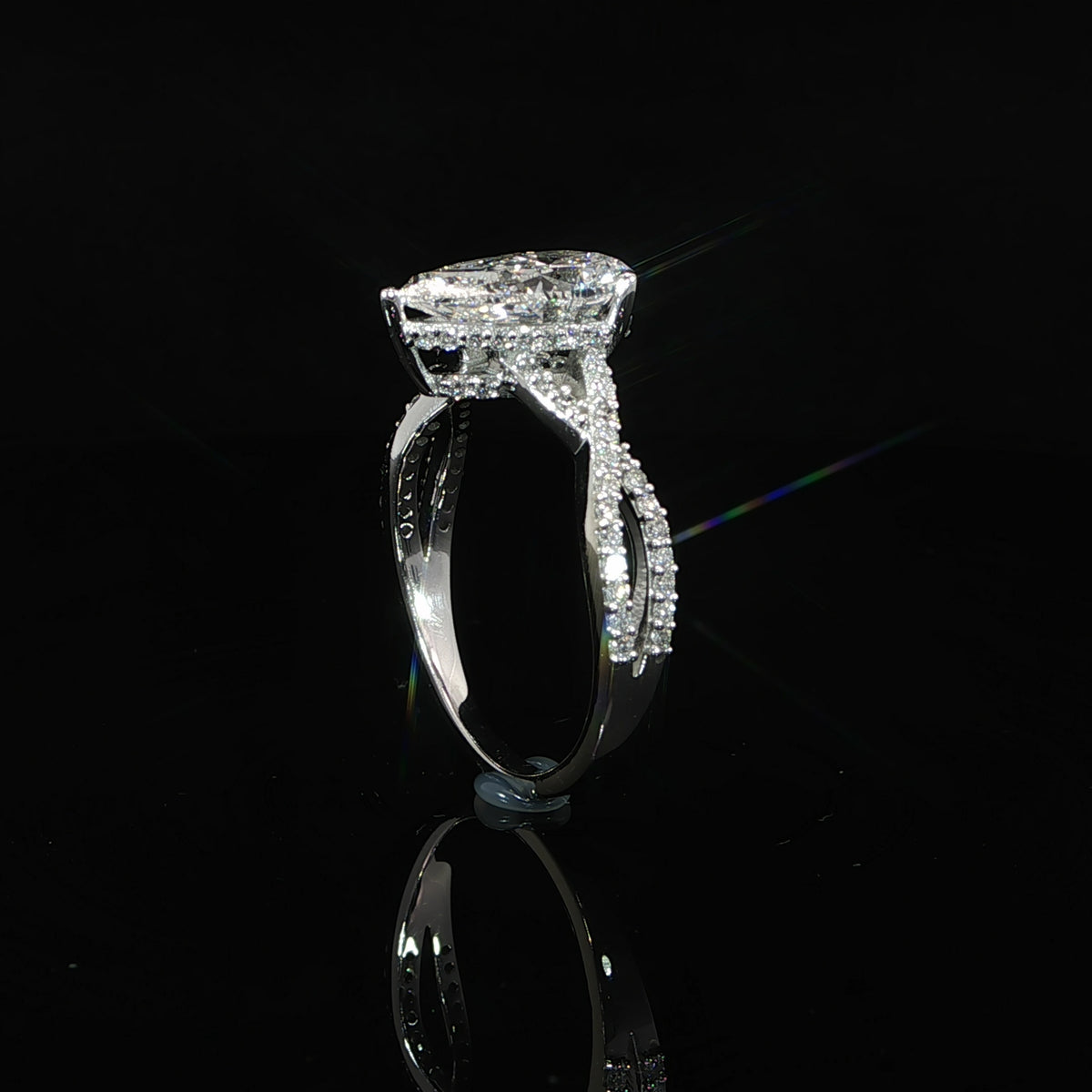 Detailed view of the hidden halo encircling the base of the 2-carat pear center diamond.