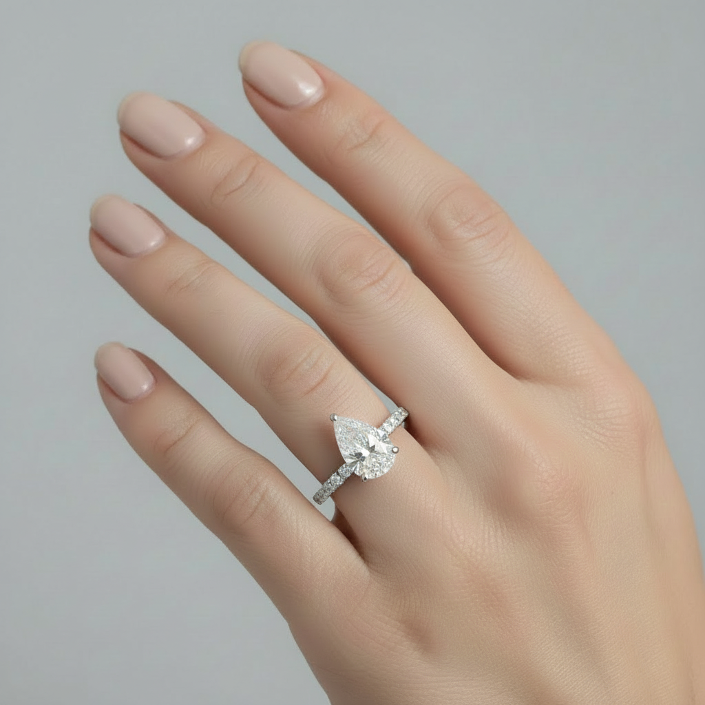 Pear-shaped diamond engagement ring with diamond band