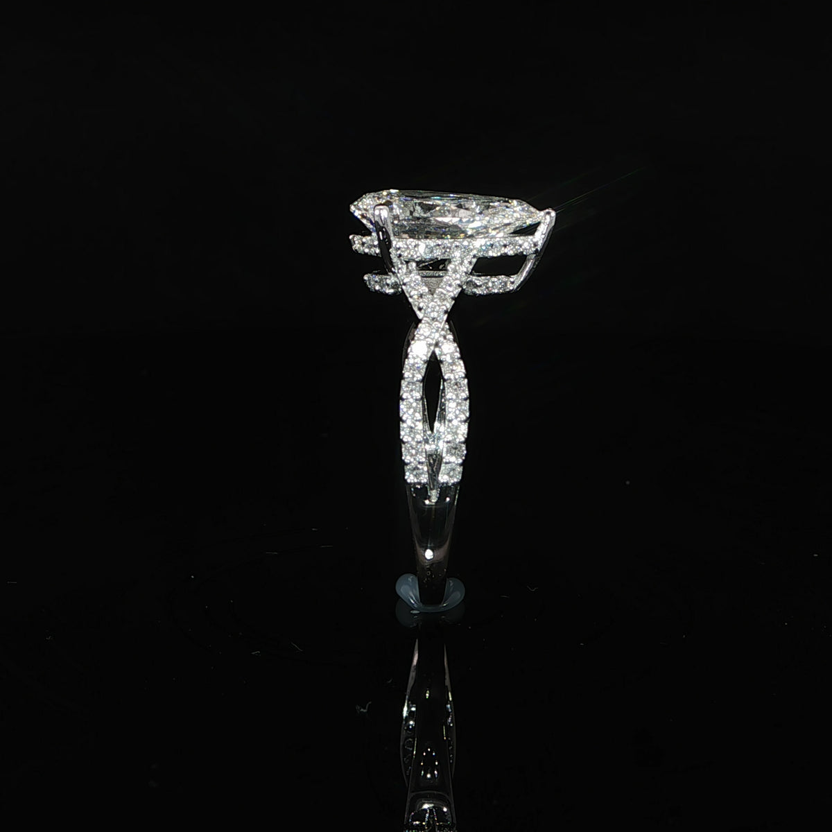 Side profile showing the hidden diamond halo beneath the pear-shaped lab-grown center stone.
