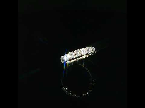 Tilted view of lab-grown emerald-cut diamonds showing step-cut facets and polished gold bezel borders.