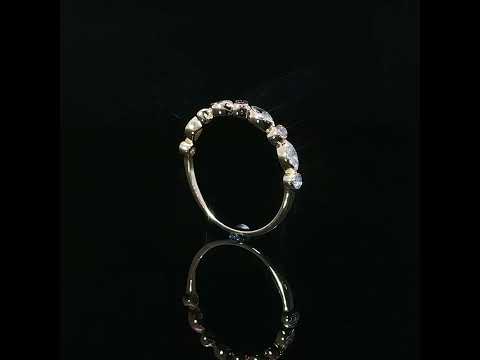 Side profile of a modern 14K yellow gold diamond band highlighting its slim polished shank and alternating marquise and round bezel set diamonds.