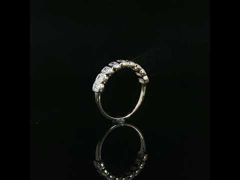 Upright half-eternity diamond band showing rectangular gold settings meeting a plain polished shank.