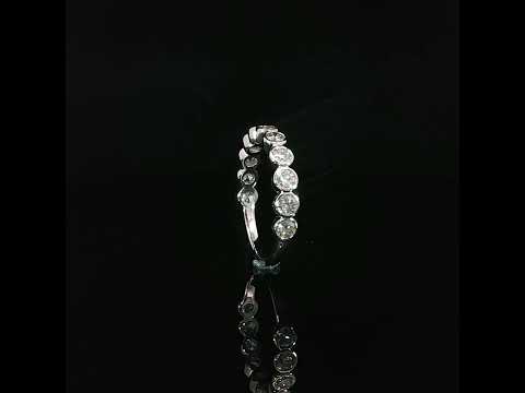 Front detail of a 14K white gold diamond band with adjoining circular settings and scalloped edges.