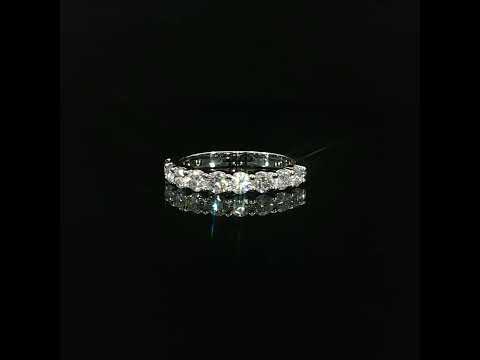 Round lab-grown diamonds held by polished gold prongs, reflected on a black surface.
