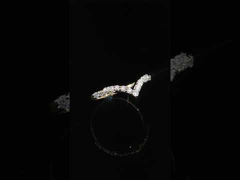 Angled detail of a 14K yellow gold contour band showing round diamonds, polished prongs and a pointed center.