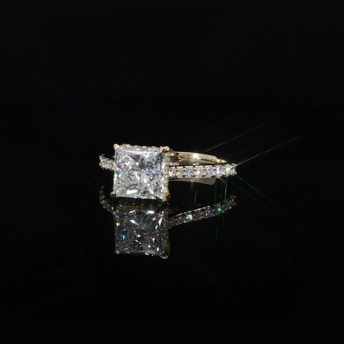 Side profile of a princess cut diamond engagement ring showing the raised cathedral setting and diamond accents.